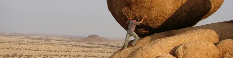 un hombre rodando una piedra gigante