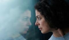 una mujer viendo su reflejo en la ventana